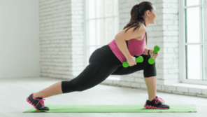 The girl performs a dumbbell workout